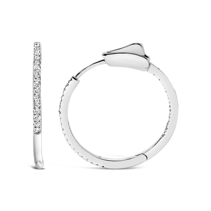 Front and side view of white metal hoop earrings featuring round white gemstones set in prongs along the outer surface.