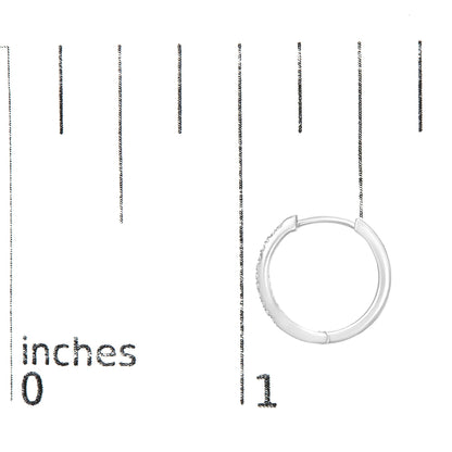 White metal hoop earring with round white gemstones set on the outer front side, shown on a ruler for size reference, front angle.