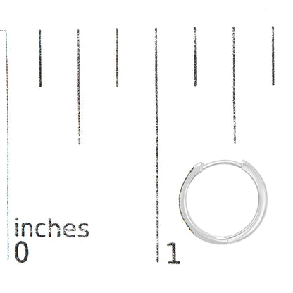 Close-up top view of a white metal hoop earring with round yellow gemstones set in prongs, placed on a ruler for size reference.
