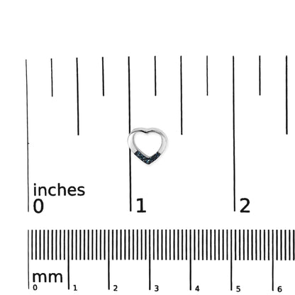 Close-up front view of a small white heart-shaped earring partially adorned with round blue gemstones, placed on a ruler for size reference.