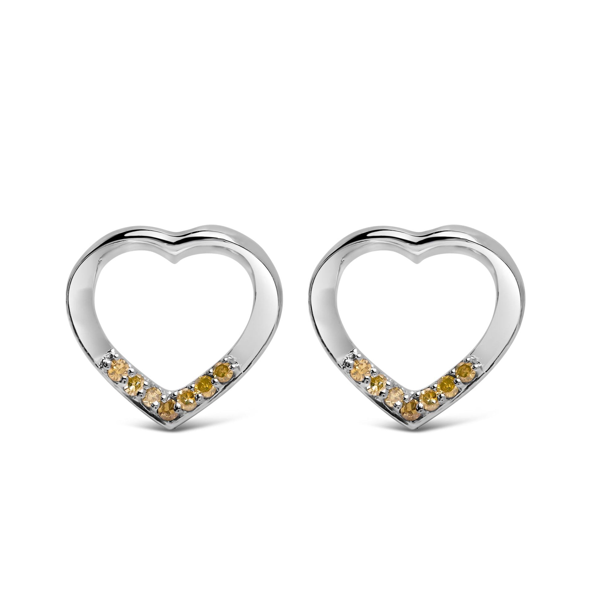 Front angle view of a pair of white heart-shaped earrings with round yellow gemstones set in prongs along the bottom inner edge.