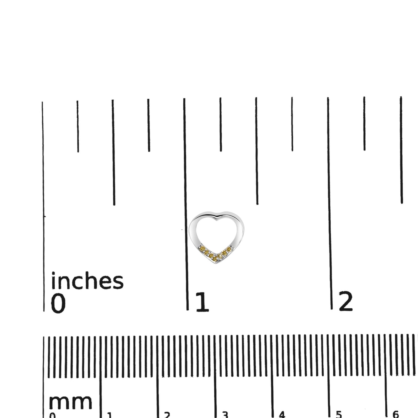 Close-up front view of a white heart-shaped earring with small yellow round gemstones along the lower curve, placed on a ruler for size reference.