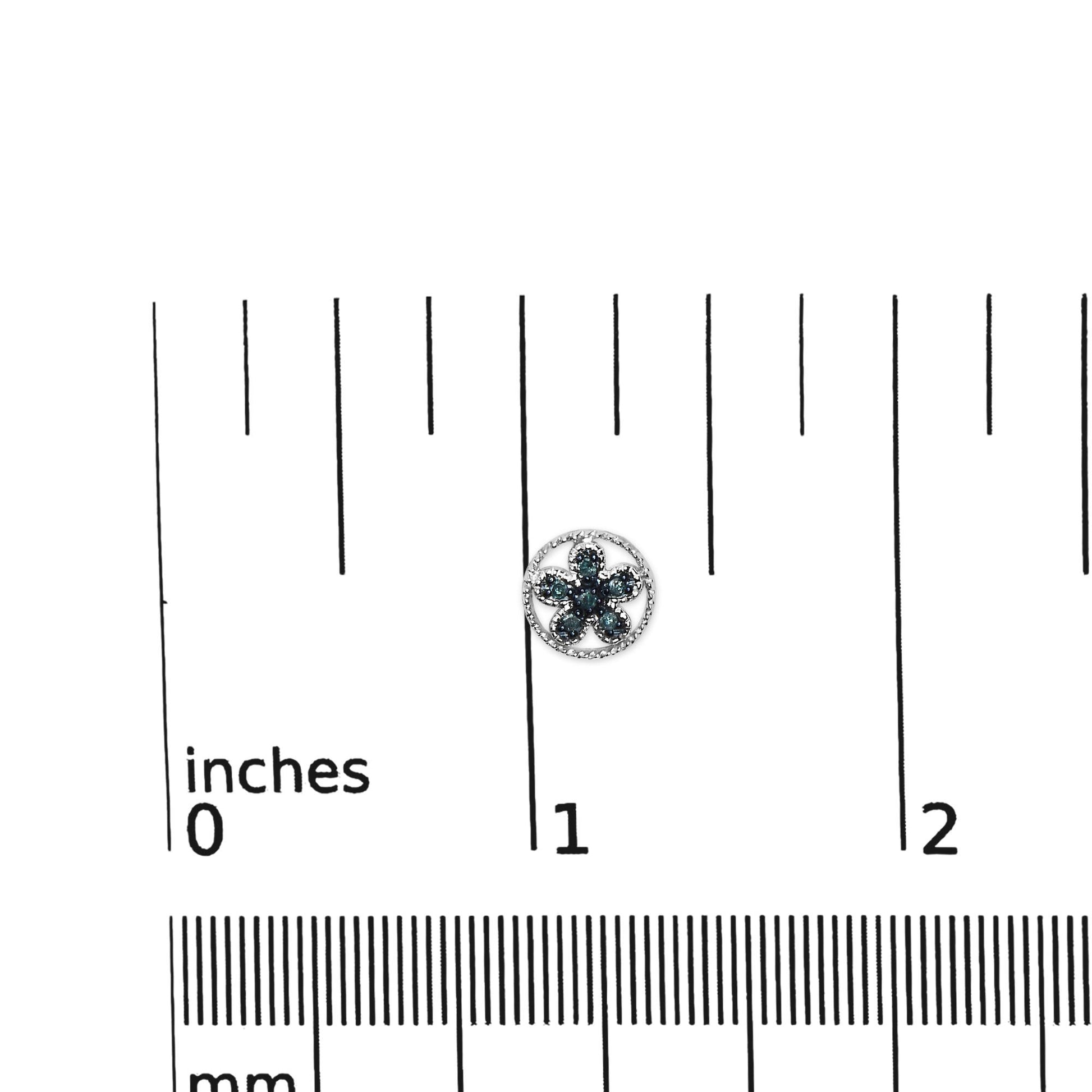 White metal round-shaped earrings with blue gemstones in prong setting, shown on a ruler for size reference from a top-down angle.