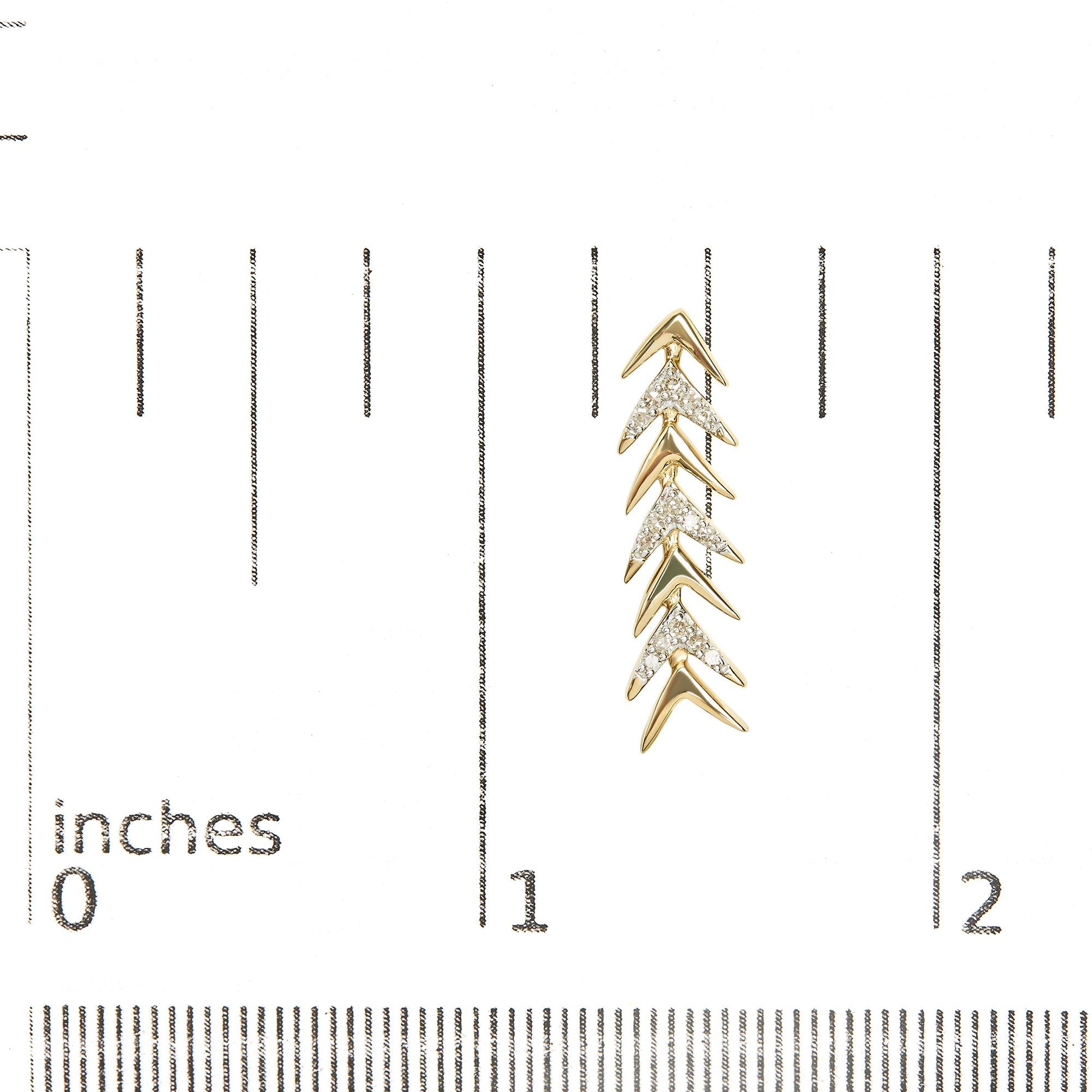 Yellow metal earrings with a chevron design, featuring multiple white round gemstones in prong settings, shown on a ruler for size reference, front angle.