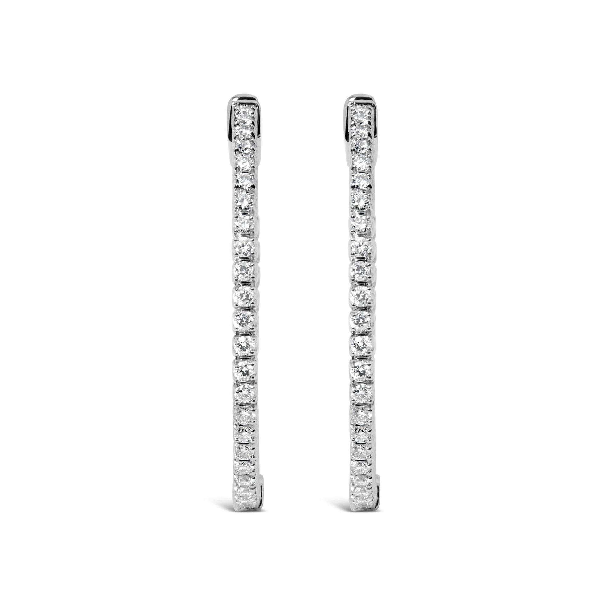 Front-facing shot of white metal long thin earrings lined with round white gemstones in prong settings.