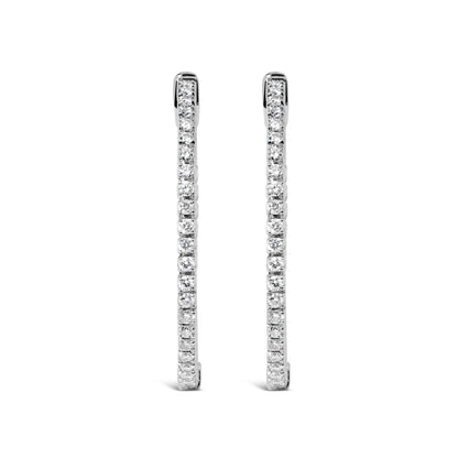 Front-facing shot of white metal long thin earrings lined with round white gemstones in prong settings.