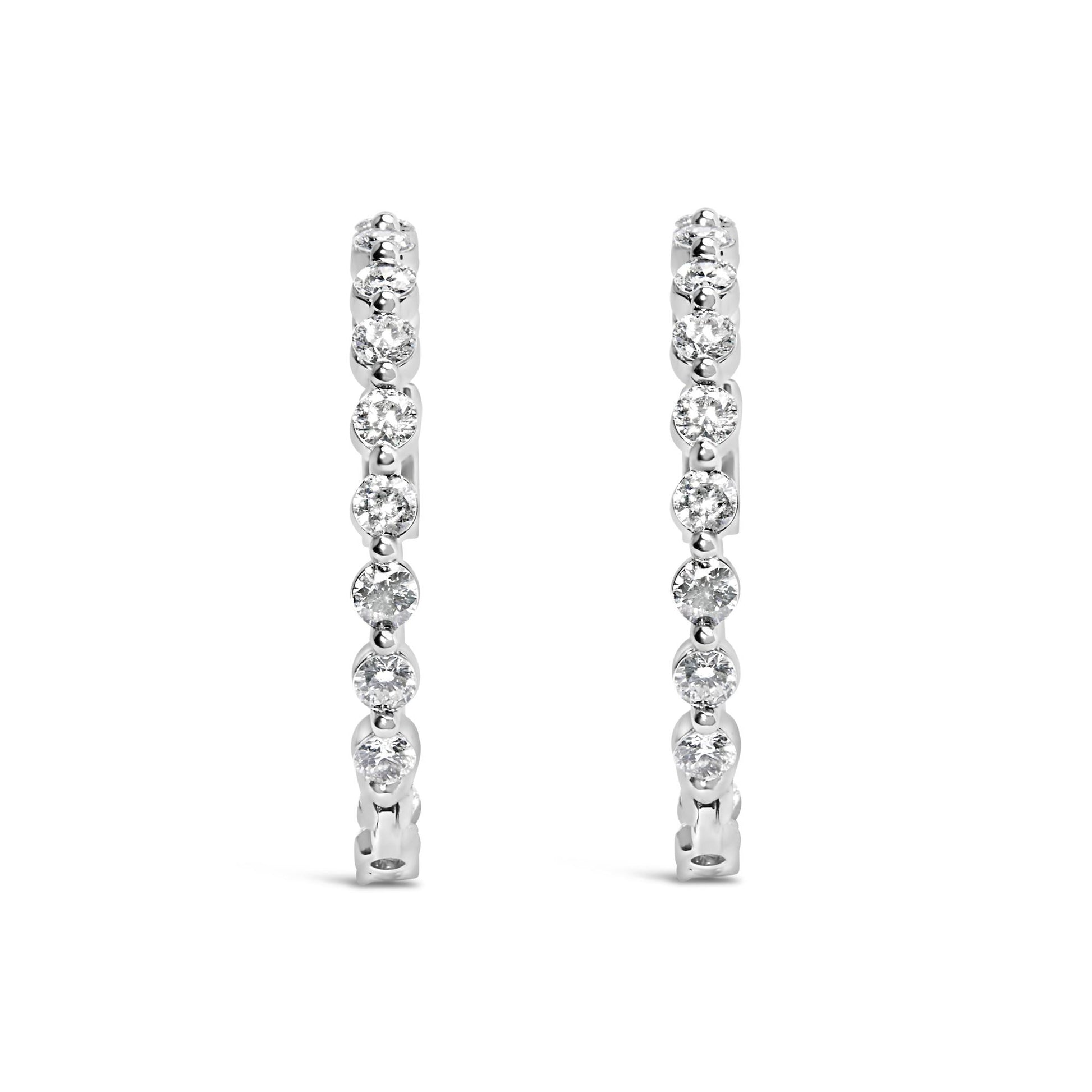 Front-facing view of a pair of white-colored metal hoop earrings, each adorned with a row of round white gemstones in 2-prong settings.