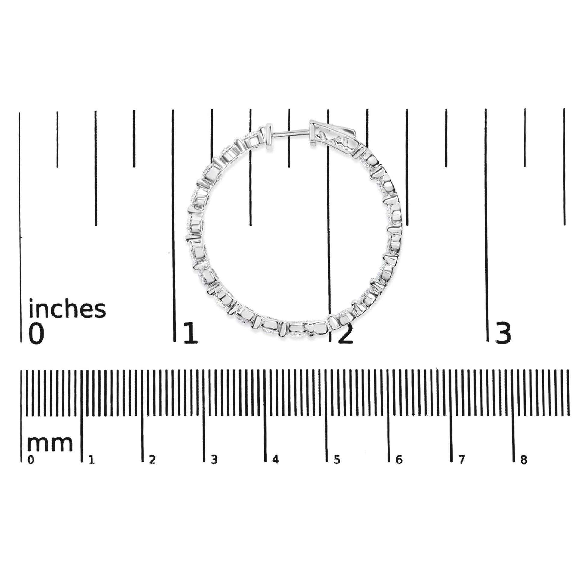 White metal hoop earring with round white gemstones in 2-prong settings, shown flat on a measurement scale, front view.