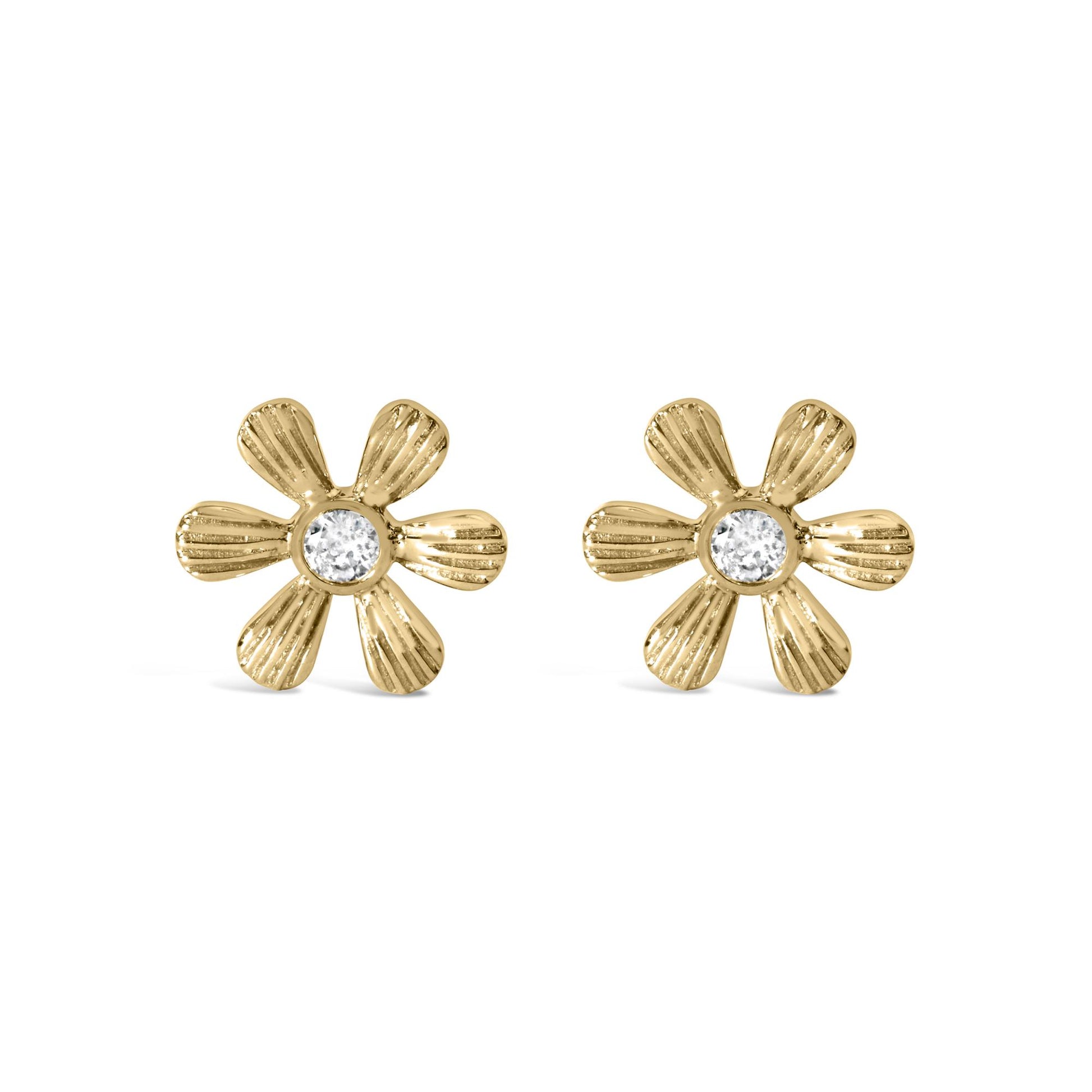 Pair of yellow metal flower-shaped earrings with textured petals and a round white gemstone in prong setting at the center, front-facing angle.