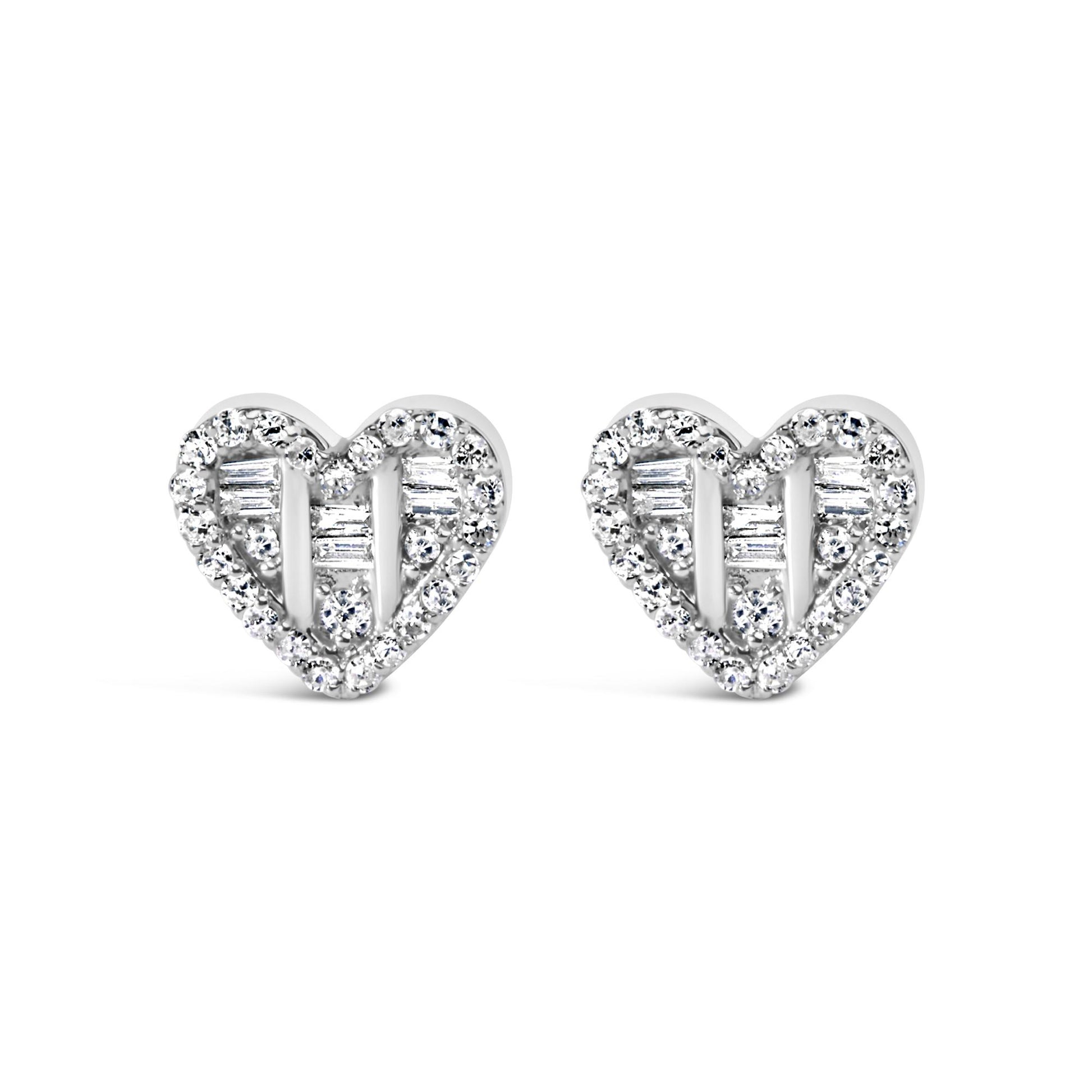 Front-facing shot of a pair of white heart-shaped earrings with round and baguette white gemstones in prong and channel settings.