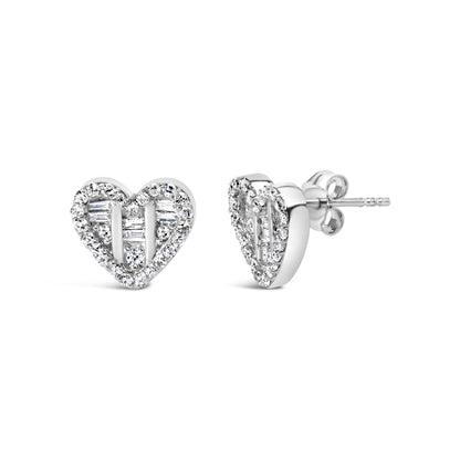 Front and side angle of white metal heart-shaped earrings studded with round and baguette white gemstones.