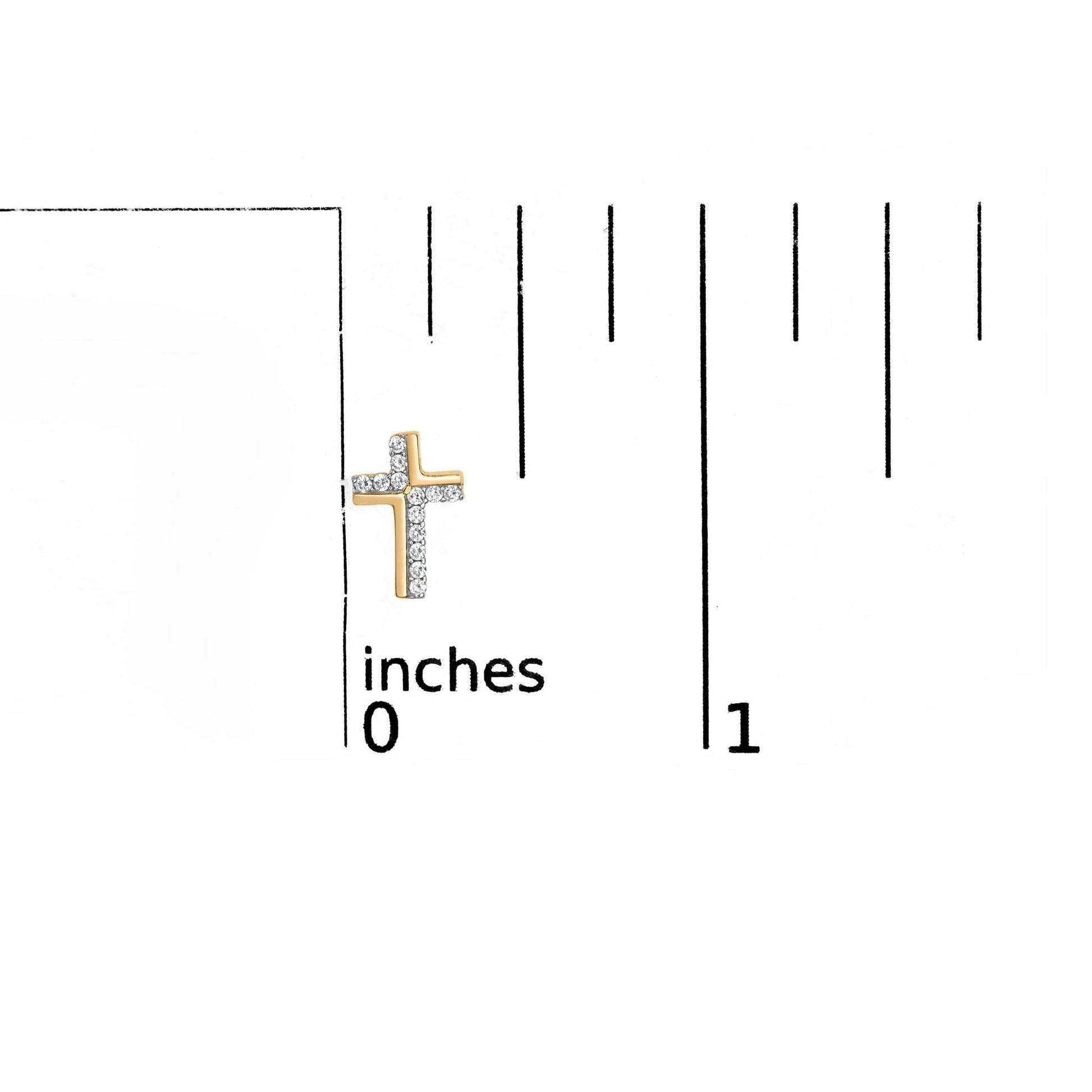 Yellow metal cross-shaped earring with white round gemstones in prong setting, shown on a ruler for size reference, front angle.