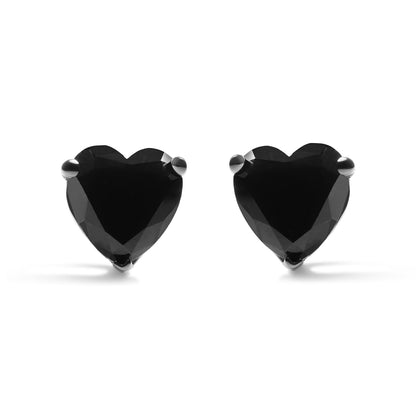 Front view of white metal heart-shaped earrings with black gemstones in prong settings.