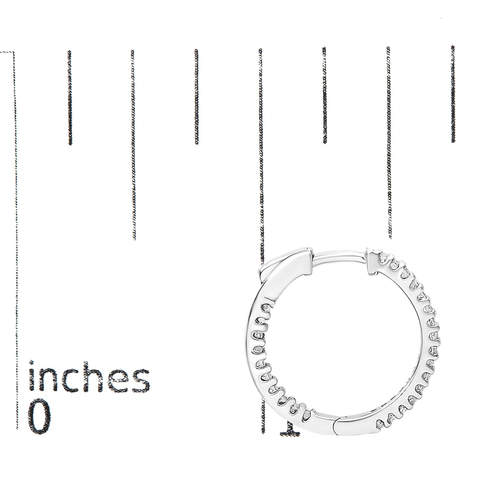 White metal hoop earring with prong-set princess shape white gemstones, shown from the front on a ruler for size reference.