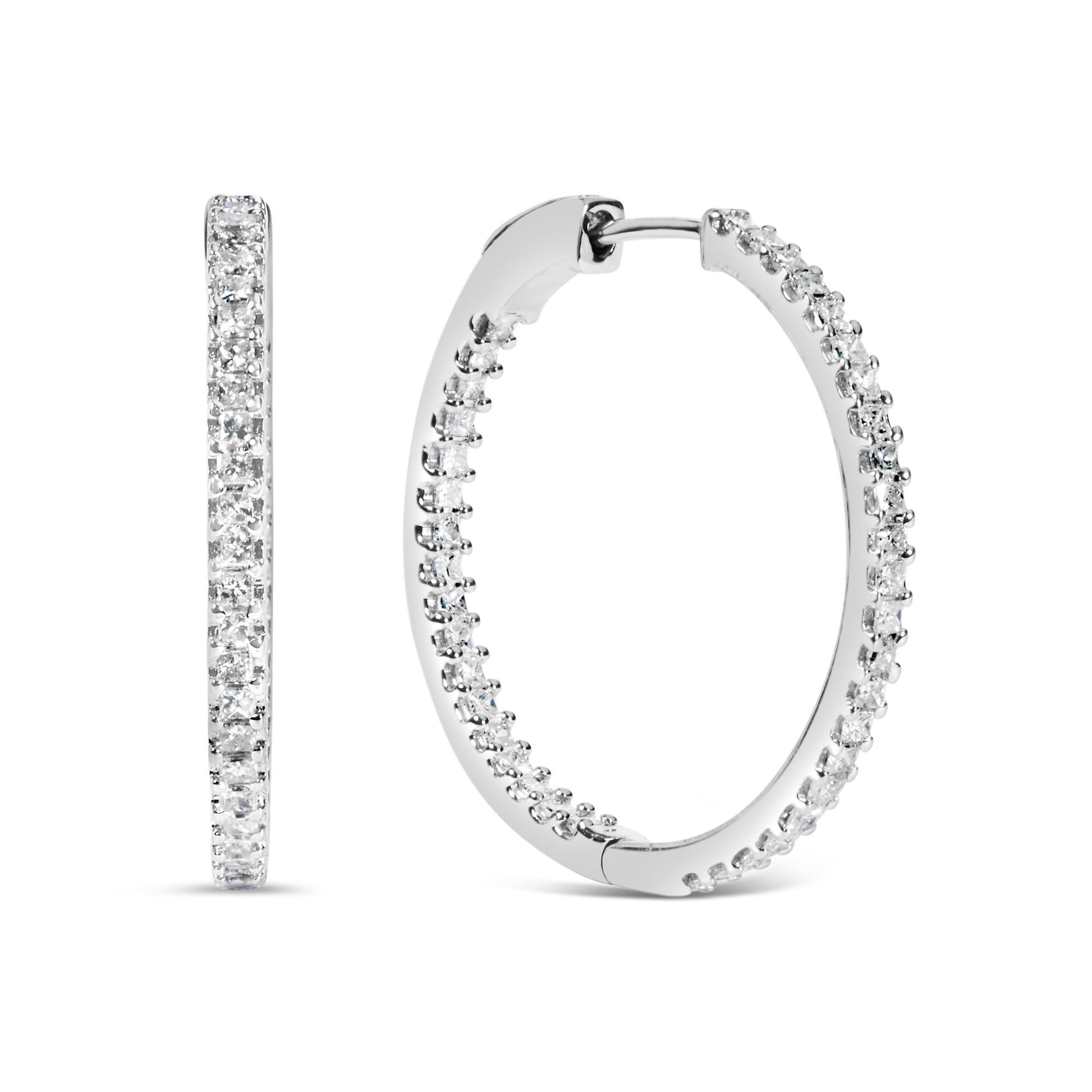 Pair of white metal hoop earrings with princess shape white gemstones in prong setting, shown from profile and front angles.