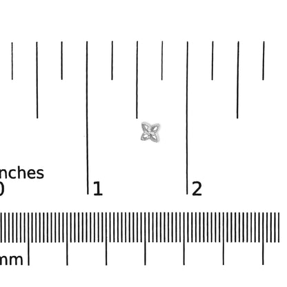 White metal stud earring with round white gemstones in prong setting, flower-like shape, shown on a ruler for size reference, top-down angle.