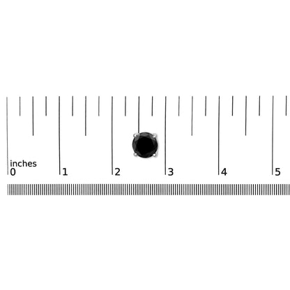 Close-up image of a single white metal earring with a round black gemstone in a four-prong setting, placed on a ruler for size reference.