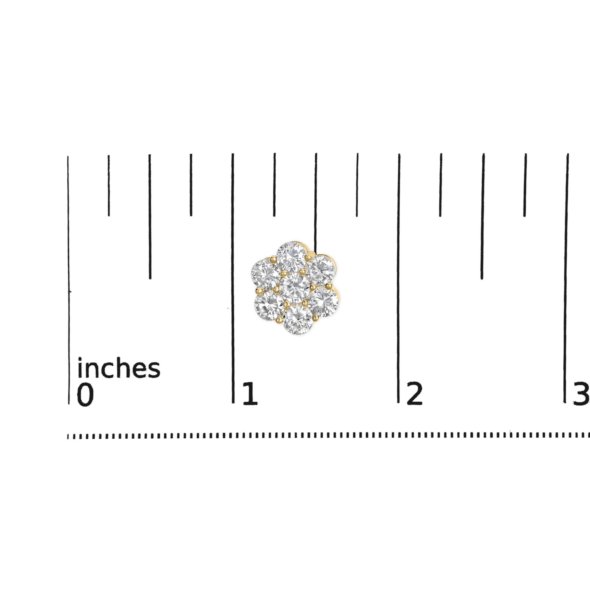 Close-up top view of yellow metal earrings with round white gemstones in prong settings, shown on a ruler for size reference.