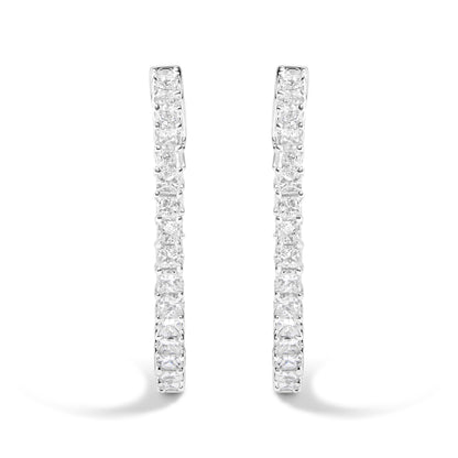 Front angle close-up of a pair of white metal hoop earrings set with square and round white gemstones in a shared prong setting.