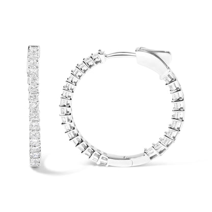 Close-up front and side view of white metal hoop earrings set with multiple princess shape white gemstones in shared prong settings.