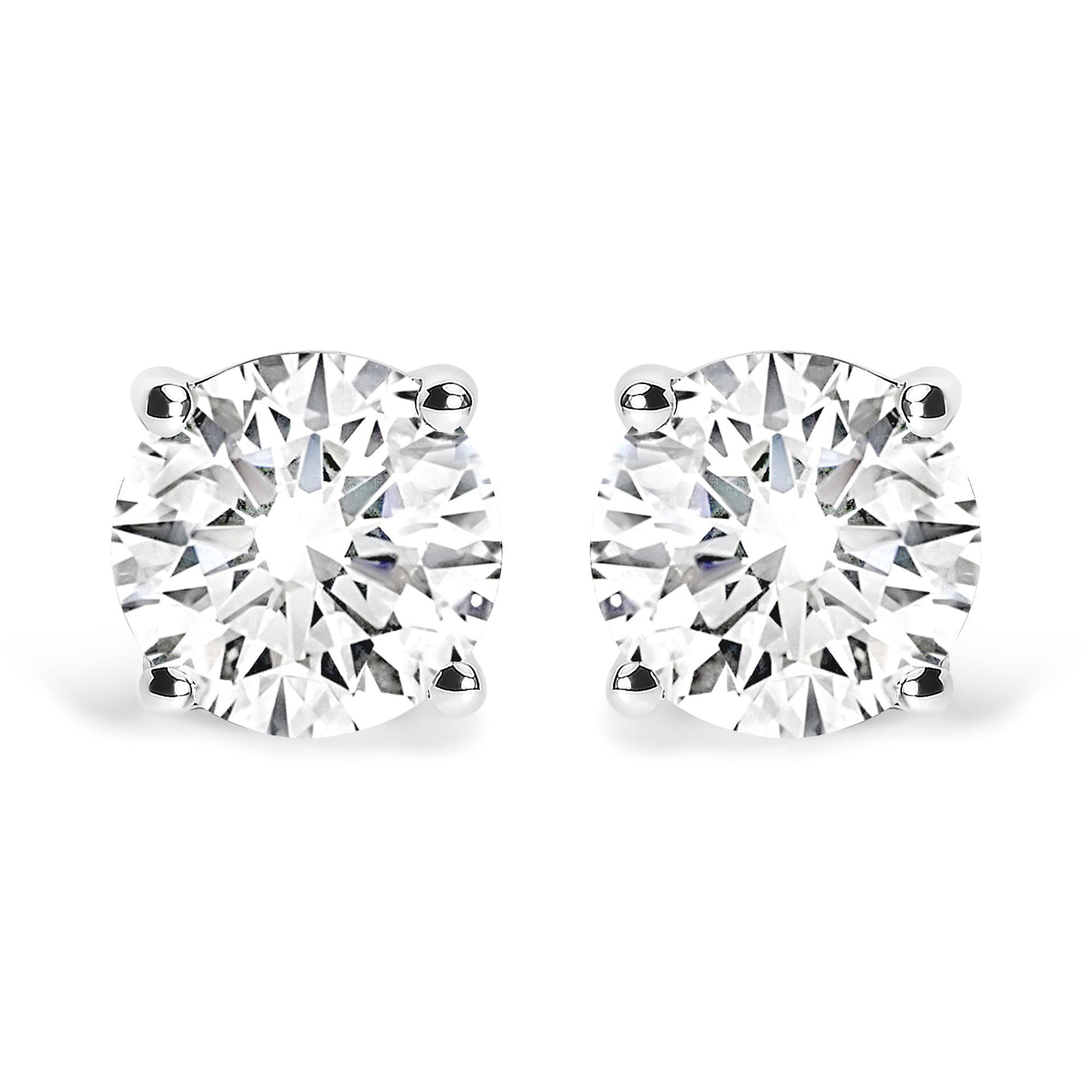 Front view of a pair of white metal stud earrings, each set with a round white gemstone in a four-prong setting.