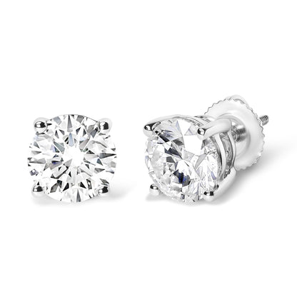 Pair of white metal stud earrings with round white gemstones in four-prong settings, shown from a front and angled side view.