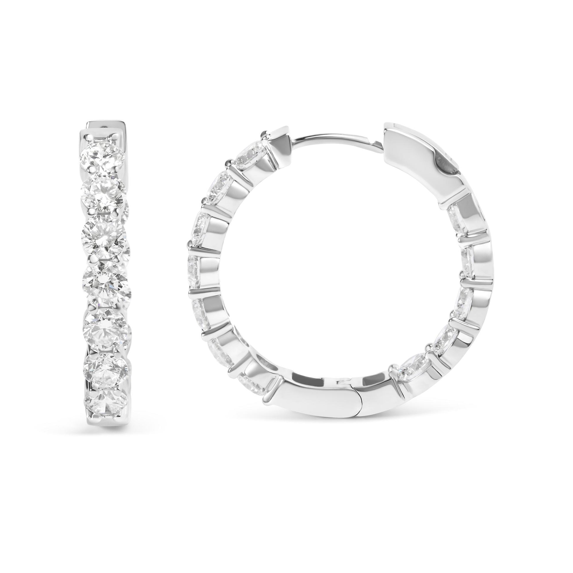 Close-up front and side view of a pair of white metal hoop earrings with round white gemstones set in shared prong setting along the outer edge, shown on a white background.