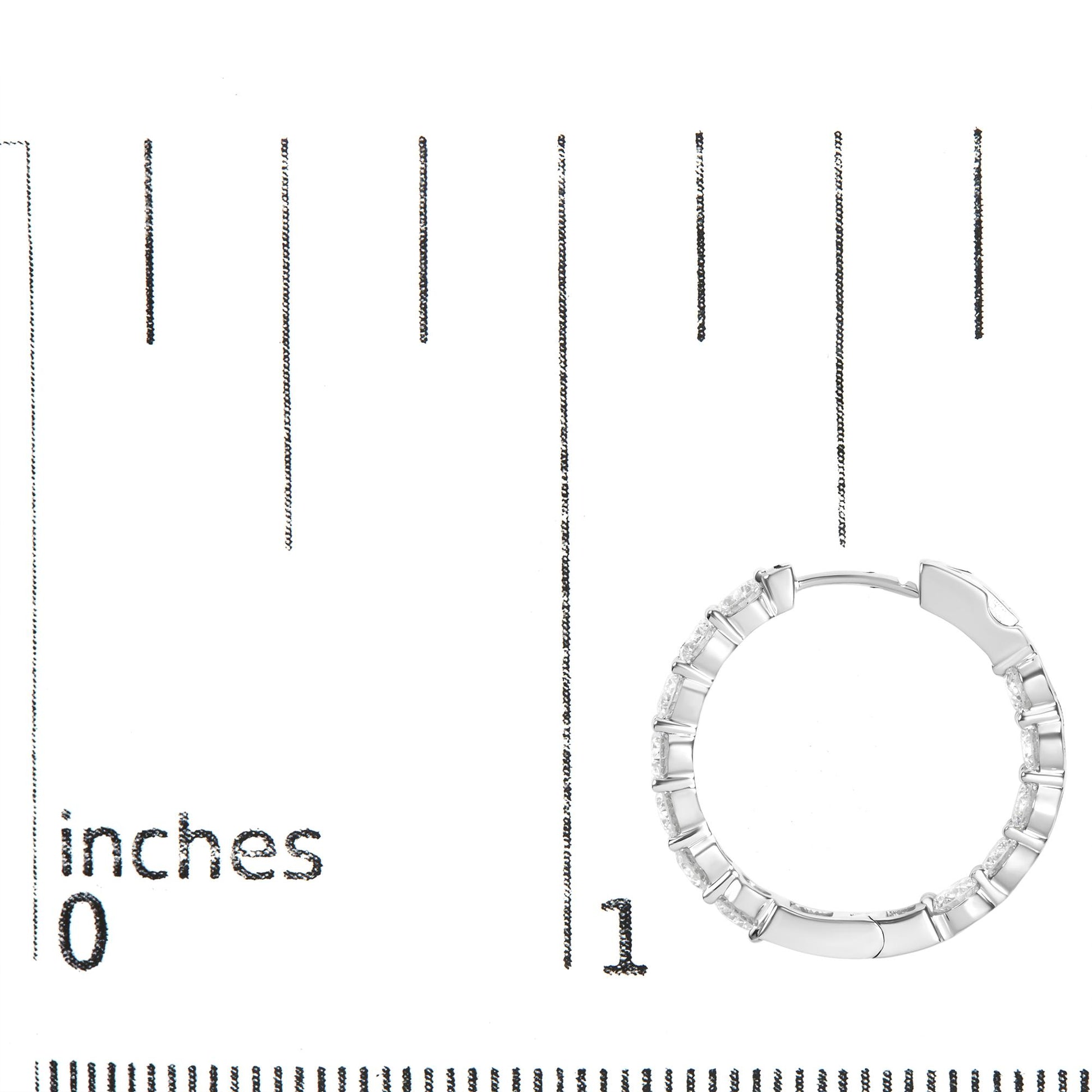 White metal hoop earring with round white gemstones in shared prong setting, shown on a scale from top down angle.