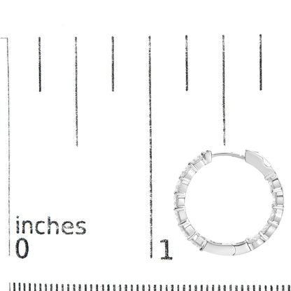 White metal hoop earring with round white gemstones in shared prong setting, shown on a scale from top down angle.