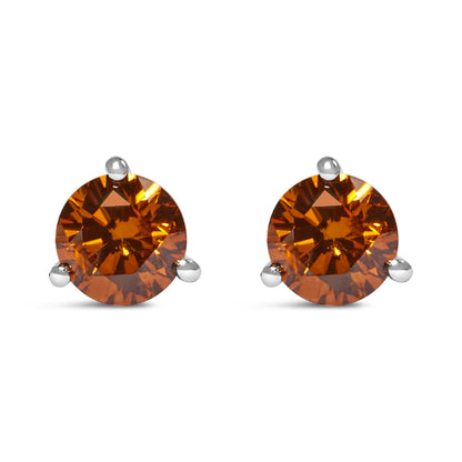 Front view of a pair of white metal stud earrings featuring round orange gemstones in three-prong settings.