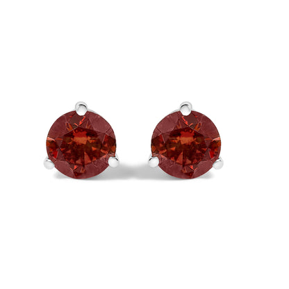 Pair of white metal stud earrings with round red gemstones in 3-prong settings, shown from the front on a white background.