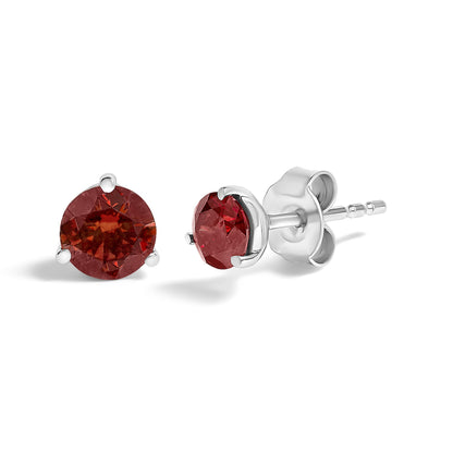 Pair of white metal stud earrings with round red gemstones in a 3-prong setting, shown from a front and side angle on a white background.
