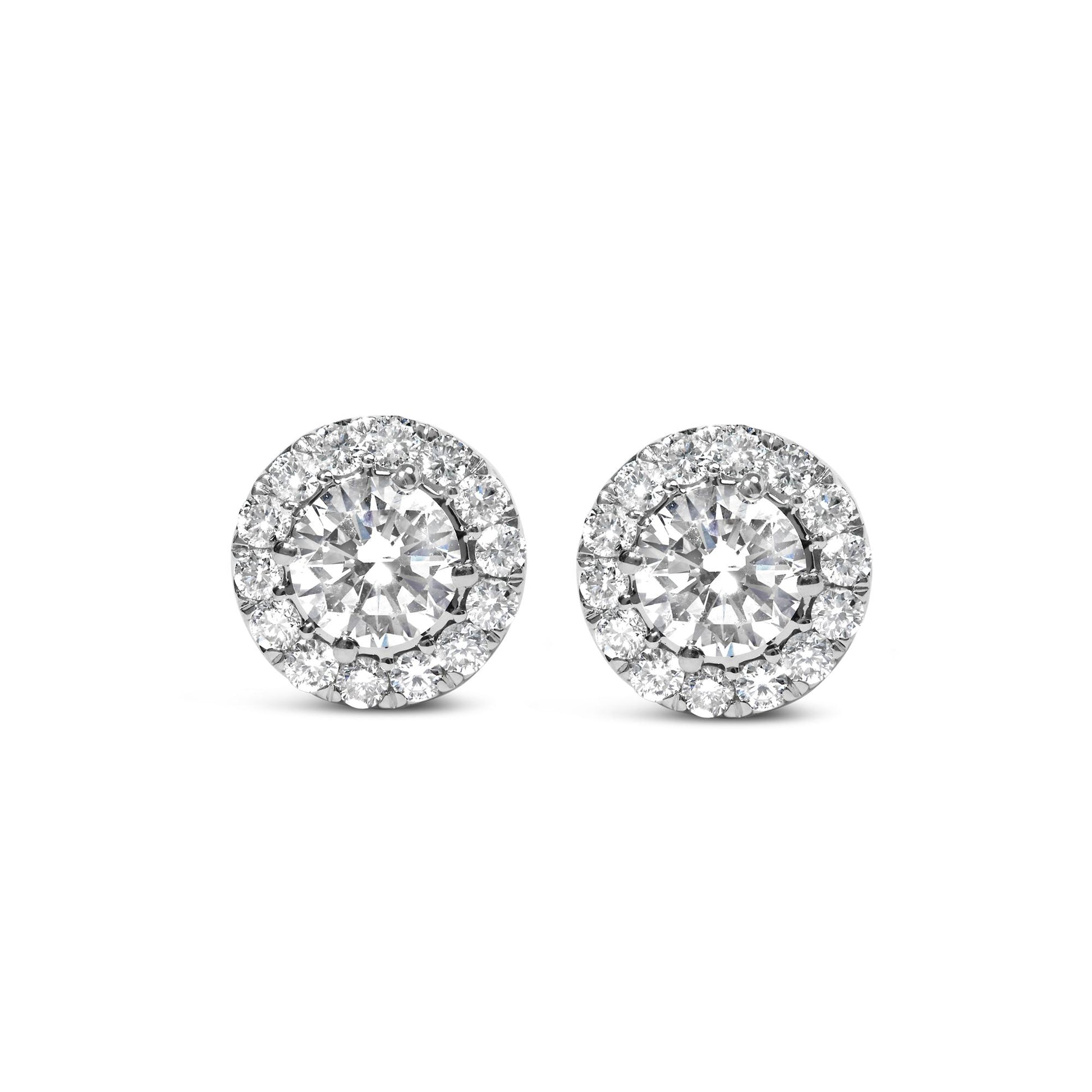 Front view of white metal round stud earrings with a large central white gemstone surrounded by a halo of smaller white gemstones.