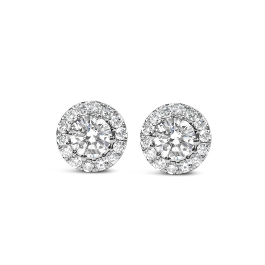 Front view of white metal round stud earrings with a large central white gemstone surrounded by a halo of smaller white gemstones.