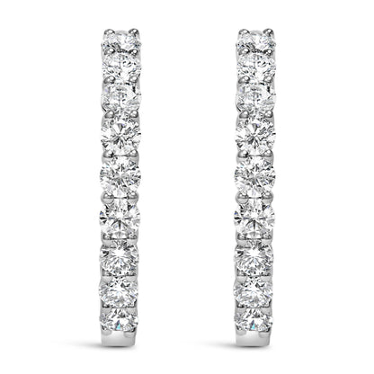 Front view of white metal hoop earrings set with round white gemstones in shared prong settings.