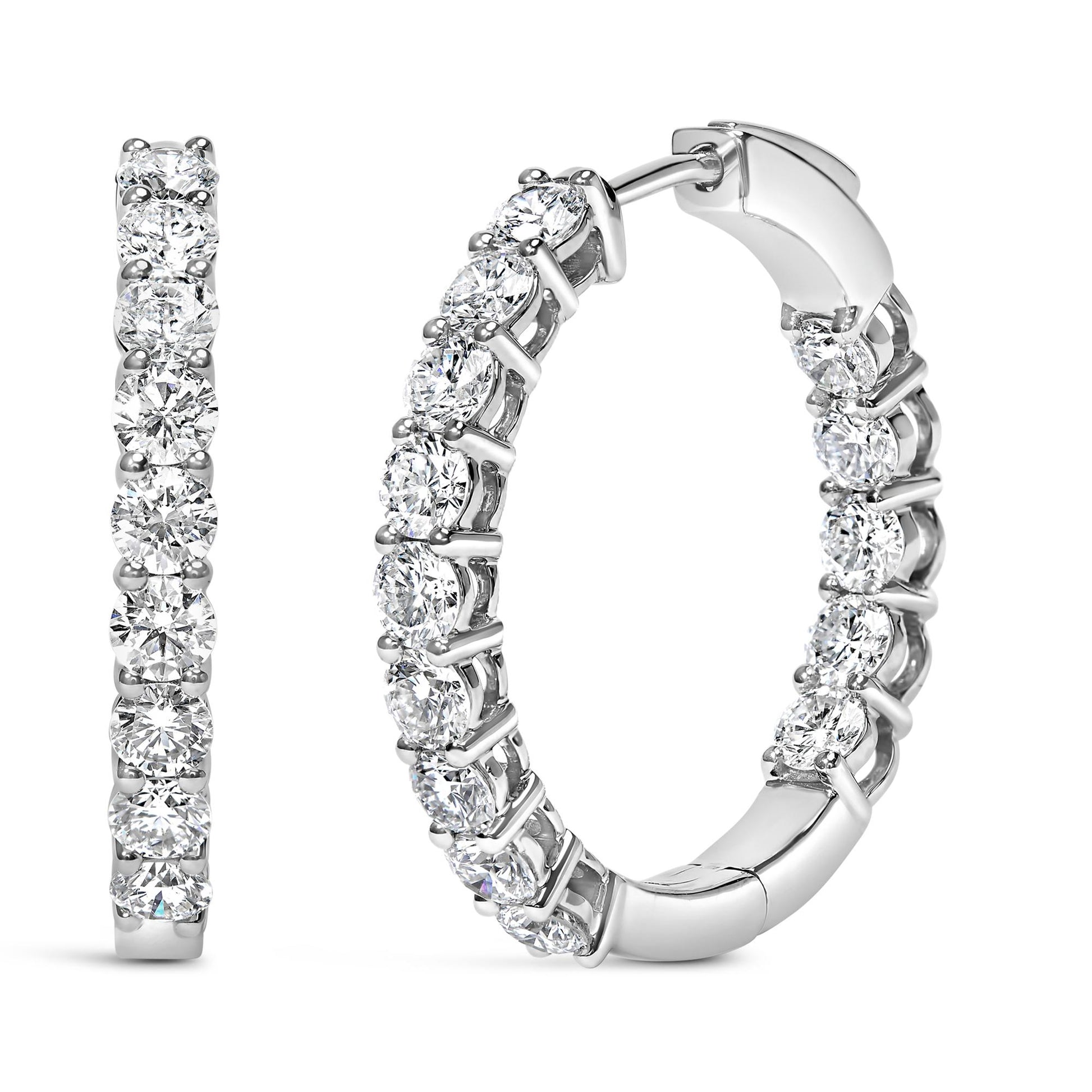 Close-up front and side view of white metal hoop earrings with round white gemstones in shared prong settings.