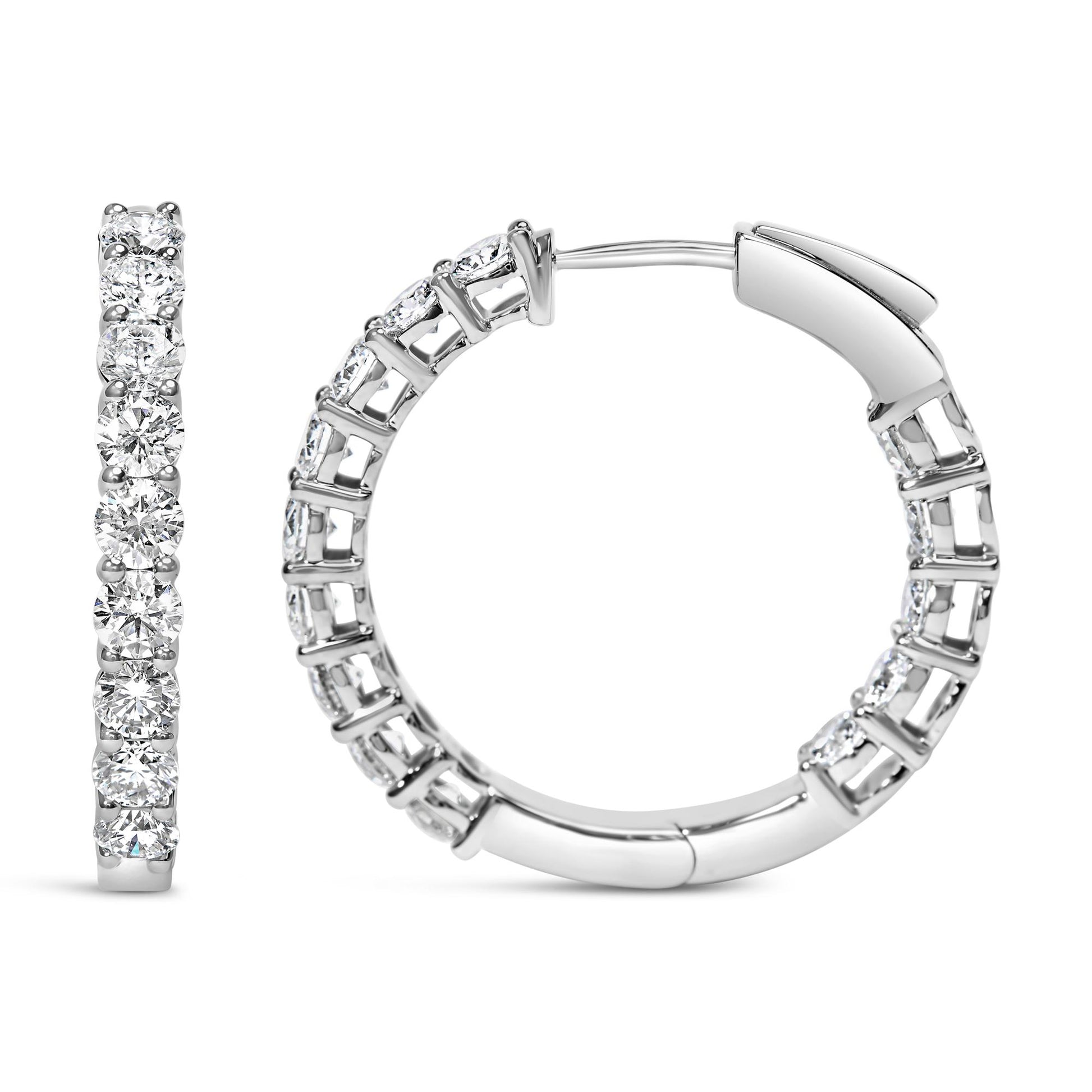 Front and side views of a pair of white metal hoop earrings with round white gemstones set in shared prong settings, shown on a white background.