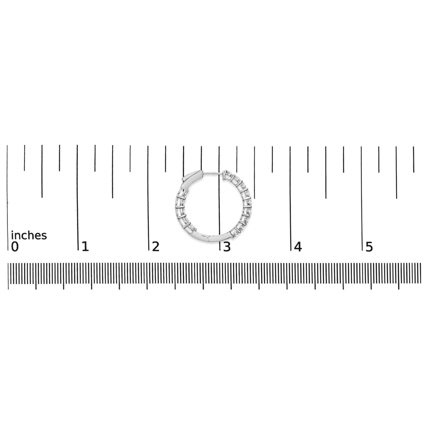 White metal hoop earring with round white gemstones in shared prong setting on a ruler for size reference, top-down angle.