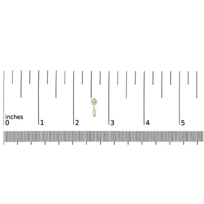 Small yellow metal earring with round white gemstones in prong setting, shown on a ruler for size reference, top-down angle.