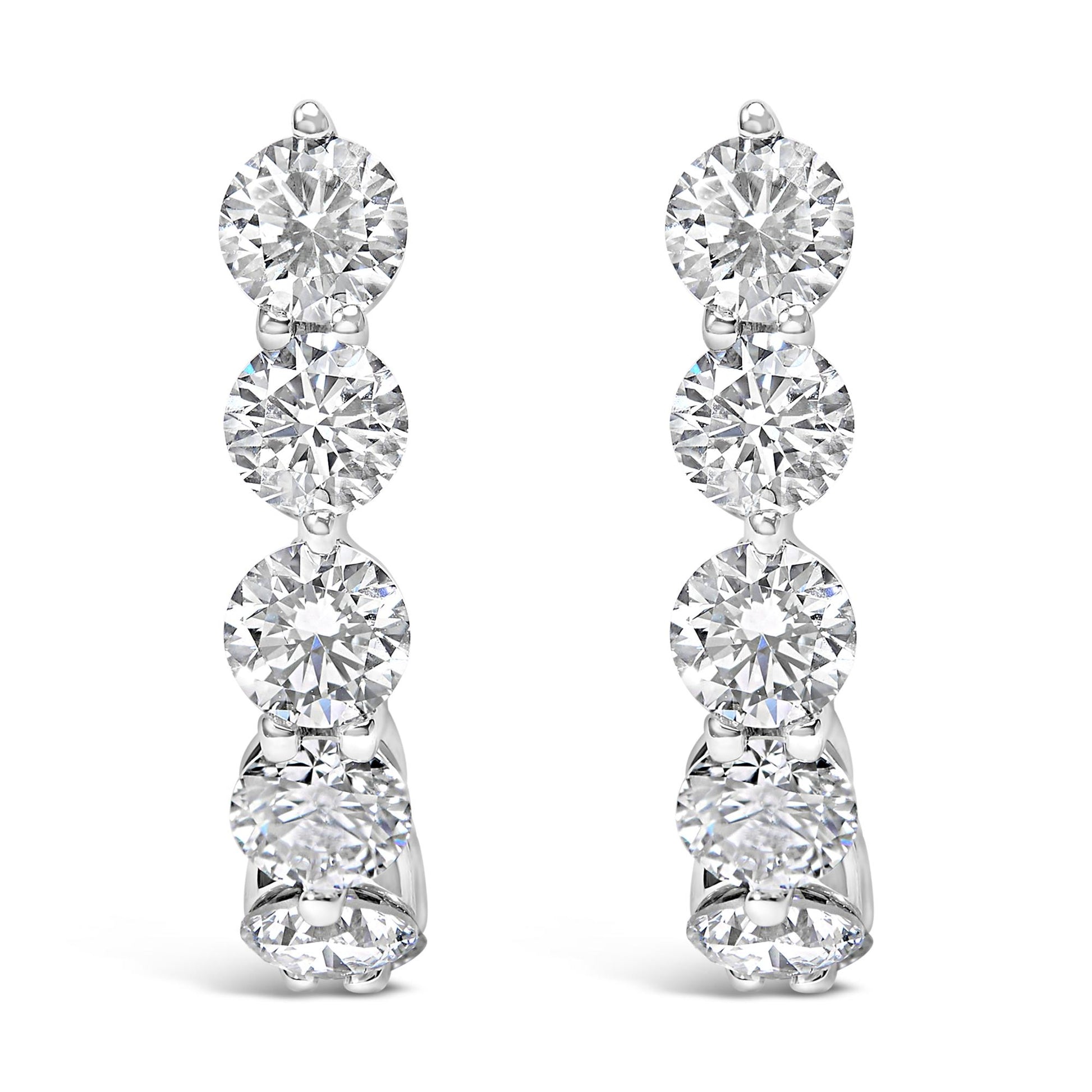 Front view of white metal earrings featuring a vertical row of round white gemstones in prong settings.