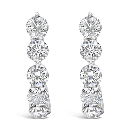 Front view of white metal earrings featuring a vertical row of round white gemstones in prong settings.