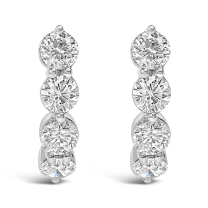 Front view of pair of white metal earrings each set with multiple round white gemstones in prong settings arranged vertically.