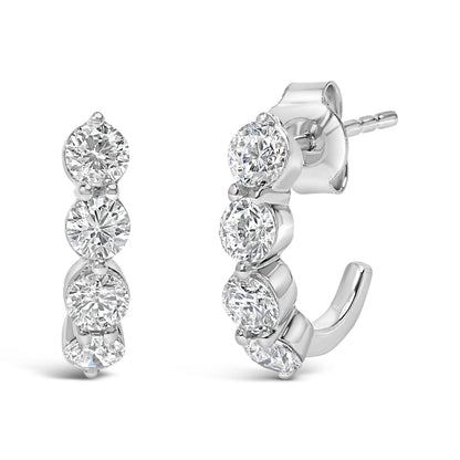 Front and side view of white metal earrings with multiple round white gemstones in prong settings, shown against a white background.