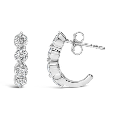 Front and side angled view of white metal earrings featuring round white gemstones in prong settings arranged vertically.