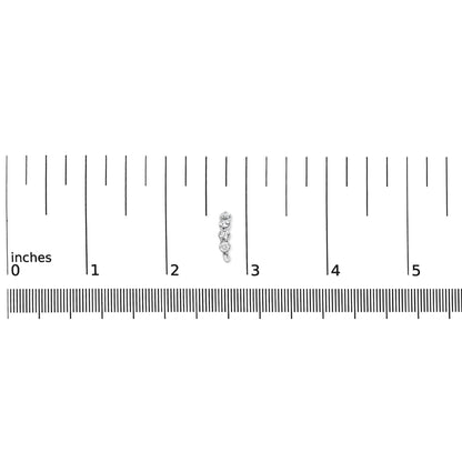 Close-up top view of a white metal earring with round white gemstones in prong settings, placed on a ruler for size reference.