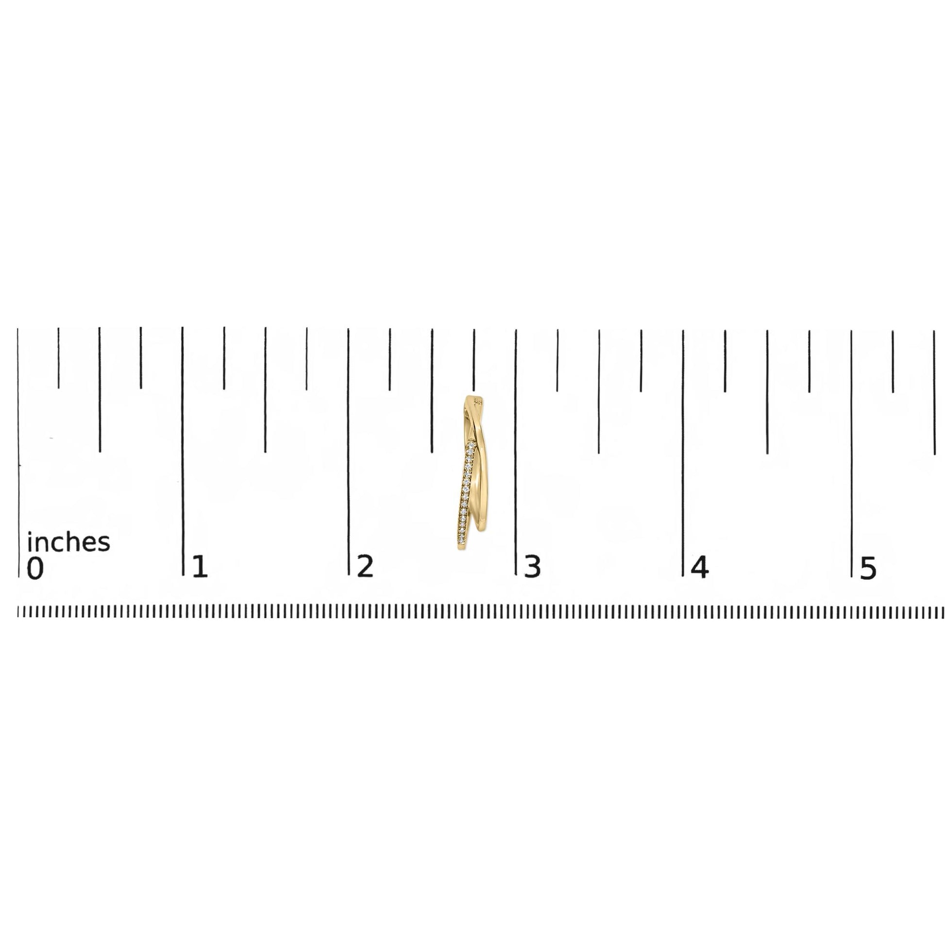 Close-up side view of a yellow metal earring with a row of small white gemstones, placed on a ruler for size reference.