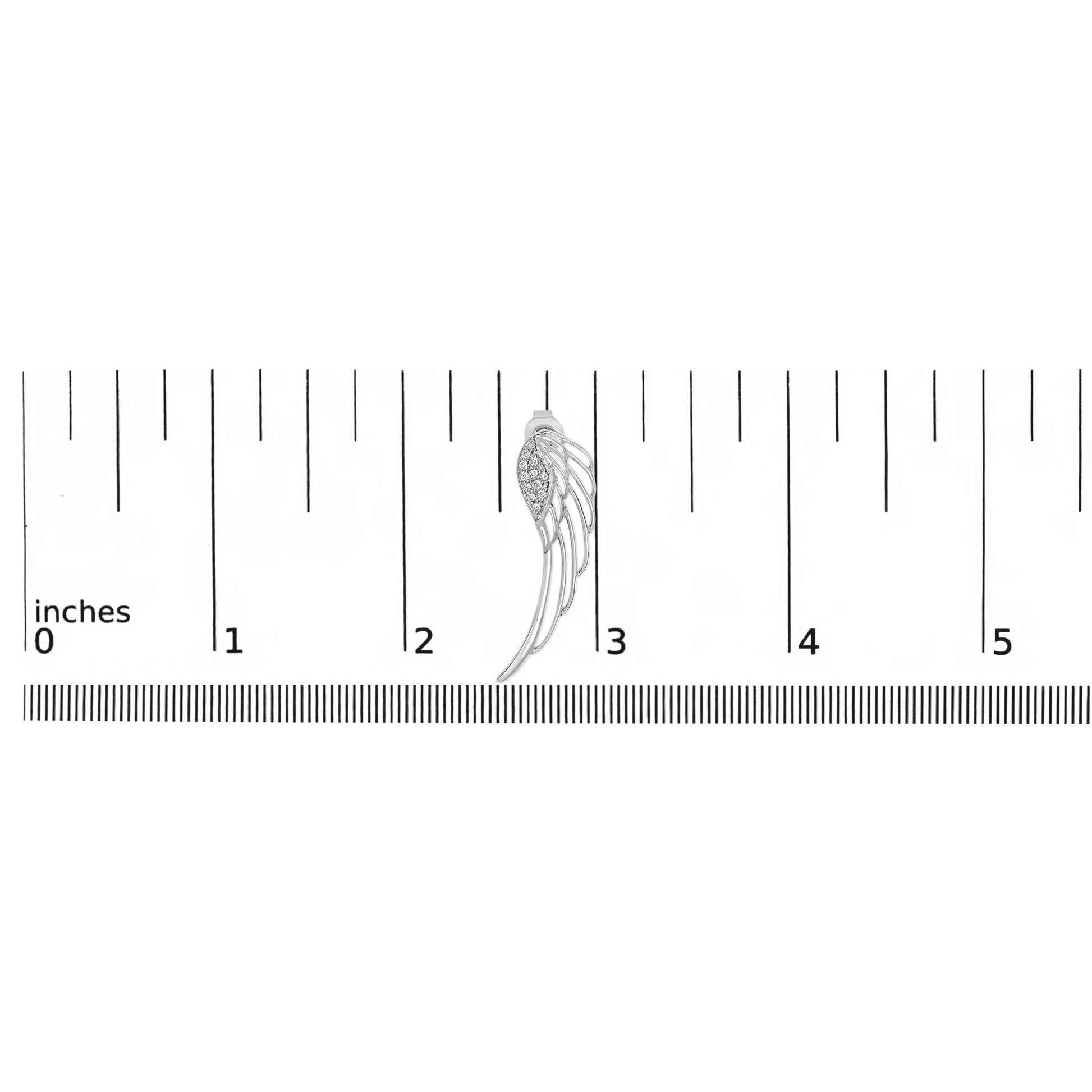 White metal earring with curved openwork design and cluster of round white gemstones, shown from front on a ruler for size reference.