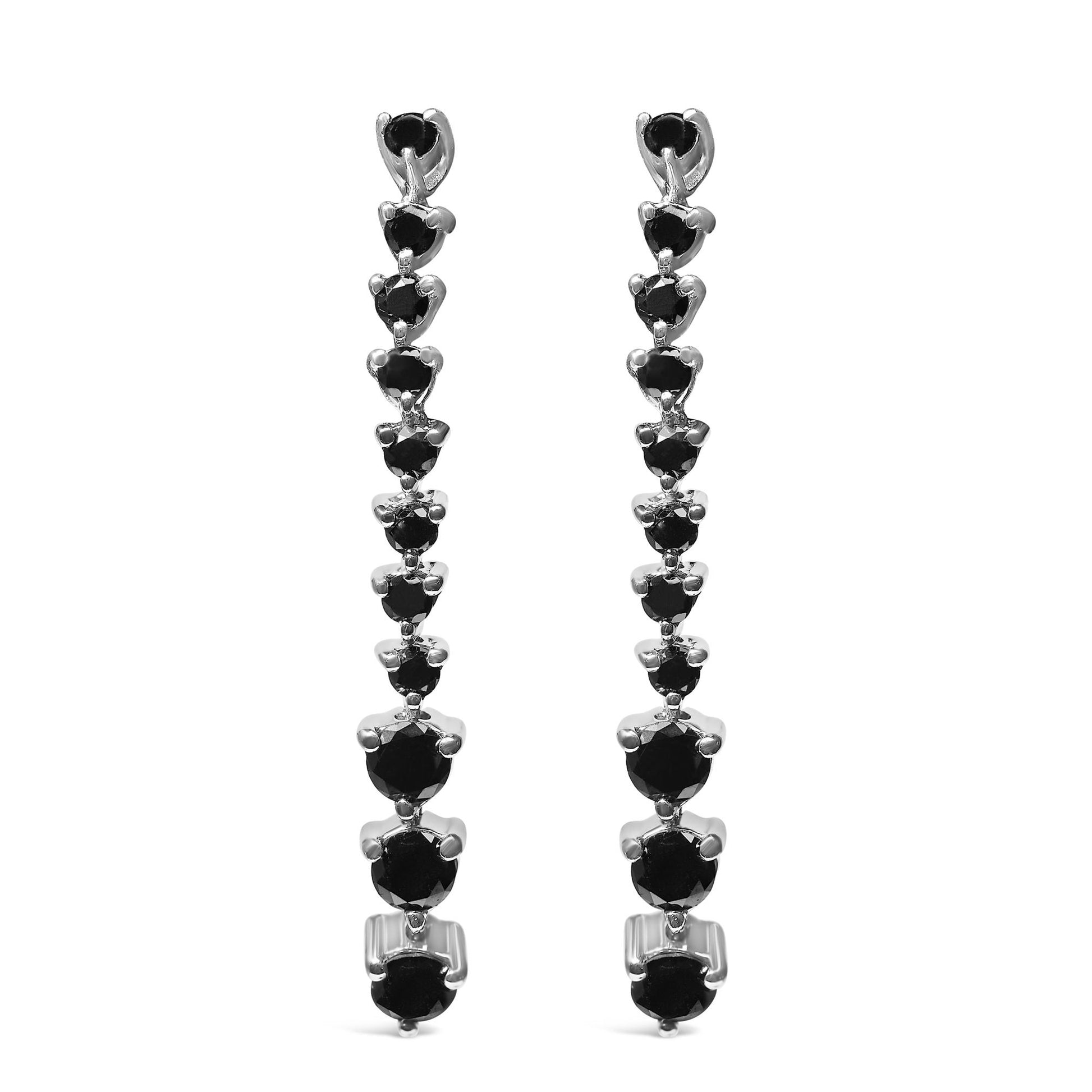 Front view of long white metal earrings with multiple round black gemstones in prong settings arranged in a descending line.