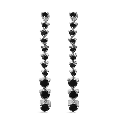 Front view of long white metal earrings with multiple round black gemstones in prong settings arranged in a descending line.