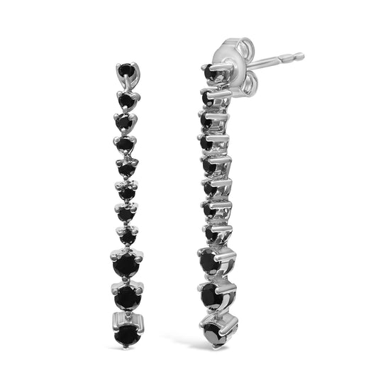 Front and side view of white metal drop earrings set with multiple black round gemstones in prong settings.